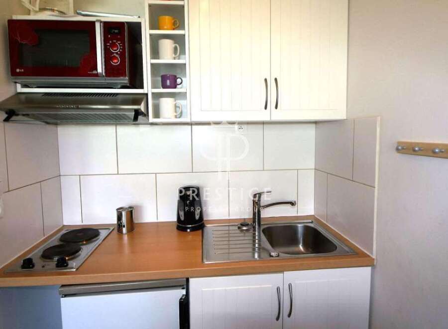 Cozy kitchenette with modern appliances, including a microwave and stovetop.