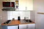Cozy kitchenette with modern appliances, including a microwave and stovetop.