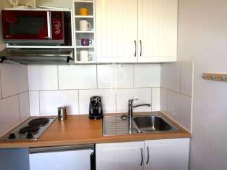 Cozy kitchenette with modern appliances, including a microwave and stovetop.
