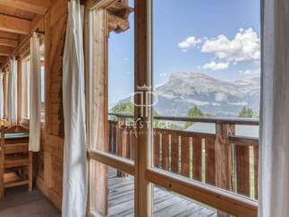 Experience breathtaking mountain views from this charming wooden chalet.