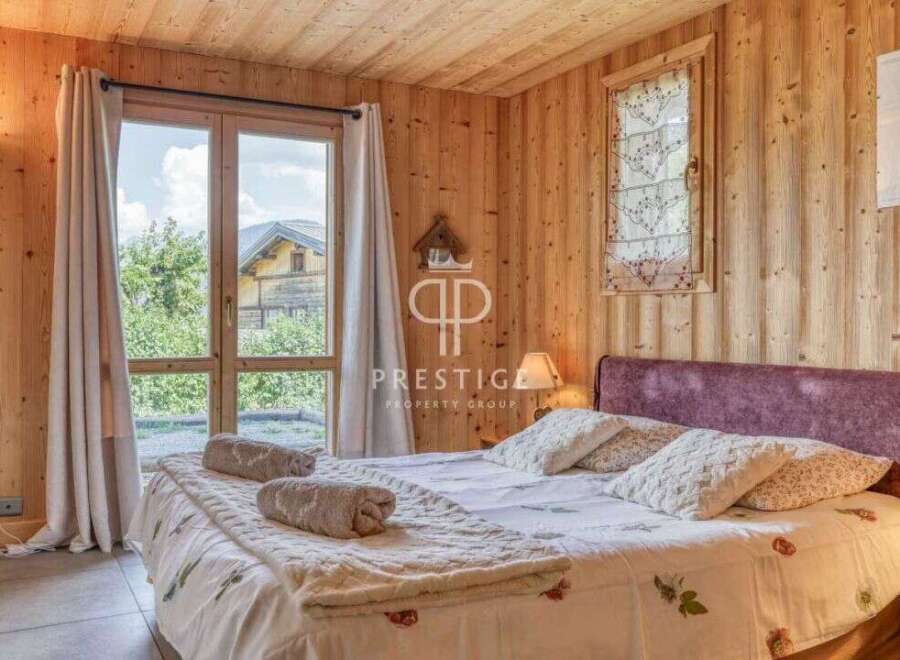 Experience the charm of this cozy bedroom with its warm wooden walls and ceiling.