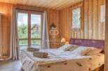 Experience the charm of this cozy bedroom with its warm wooden walls and ceiling.