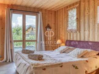 Experience the charm of this cozy bedroom with its warm wooden walls and ceiling.