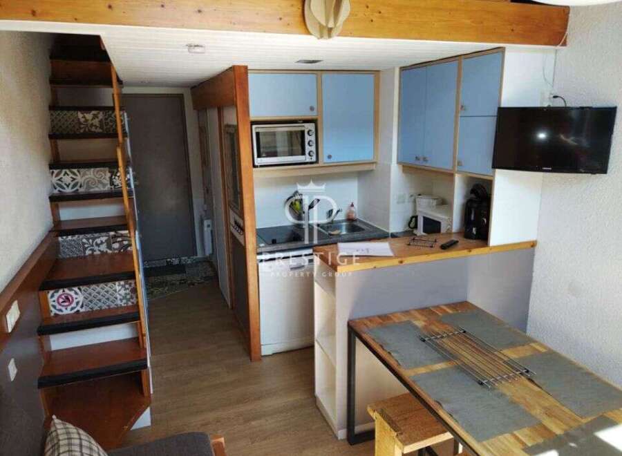 Cozy and compact living at its finest! This charming property features a well-equipped kitchen with modern appliances and stylish blue cabinetry.