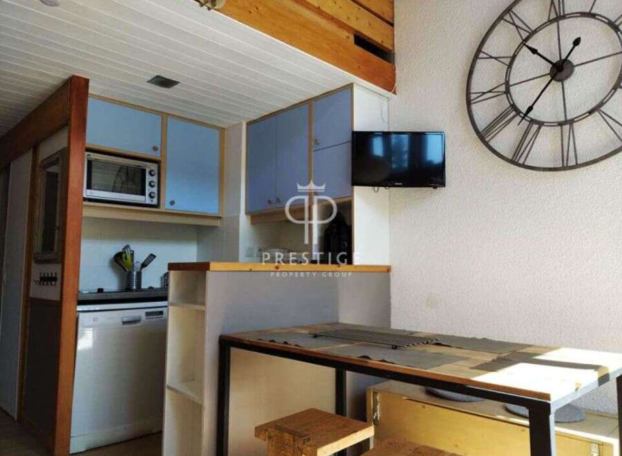 Discover this charming property featuring a well-equipped kitchen with modern appliances and stylish blue cabinetry.