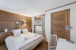 Experience the charm of this cozy bedroom, featuring a rustic wooden accent wall and a comfortable bed.
