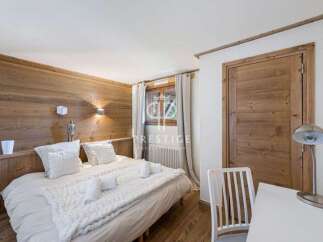 Experience the charm of this cozy bedroom, featuring a rustic wooden accent wall and a comfortable bed.