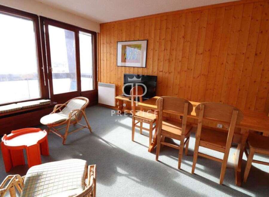 Cozy living space with natural wood paneling and ample natural light.