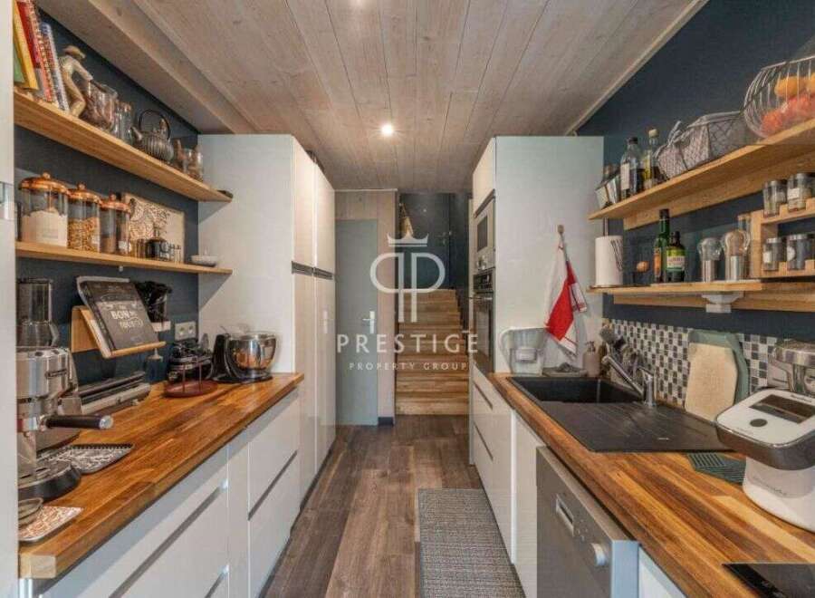 Discover a stunning kitchen with a modern design, featuring sleek white cabinetry and warm wooden countertops.