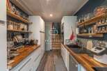 Discover a stunning kitchen with a modern design, featuring sleek white cabinetry and warm wooden countertops.
