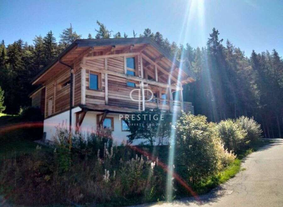 Discover a stunning wooden chalet nestled in a picturesque mountain setting.