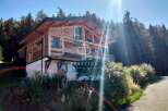 Discover a stunning wooden chalet nestled in a picturesque mountain setting.