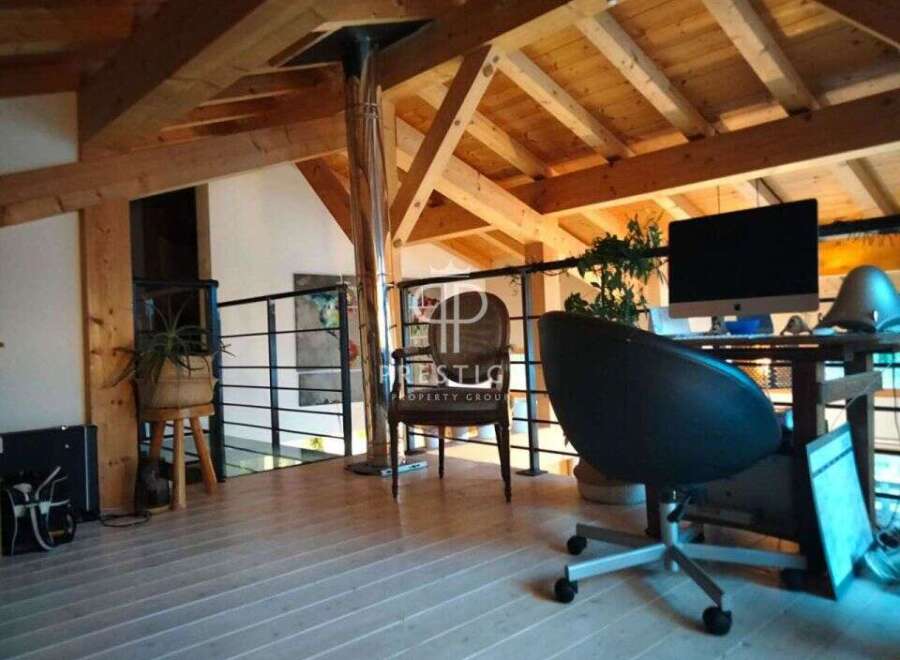 Discover the charm of this property, featuring a stylish interior with exposed wooden beams and a modern workspace.