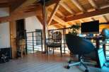 Discover the charm of this property, featuring a stylish interior with exposed wooden beams and a modern workspace.