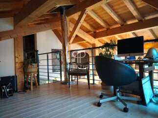 Discover the charm of this property, featuring a stylish interior with exposed wooden beams and a modern workspace.