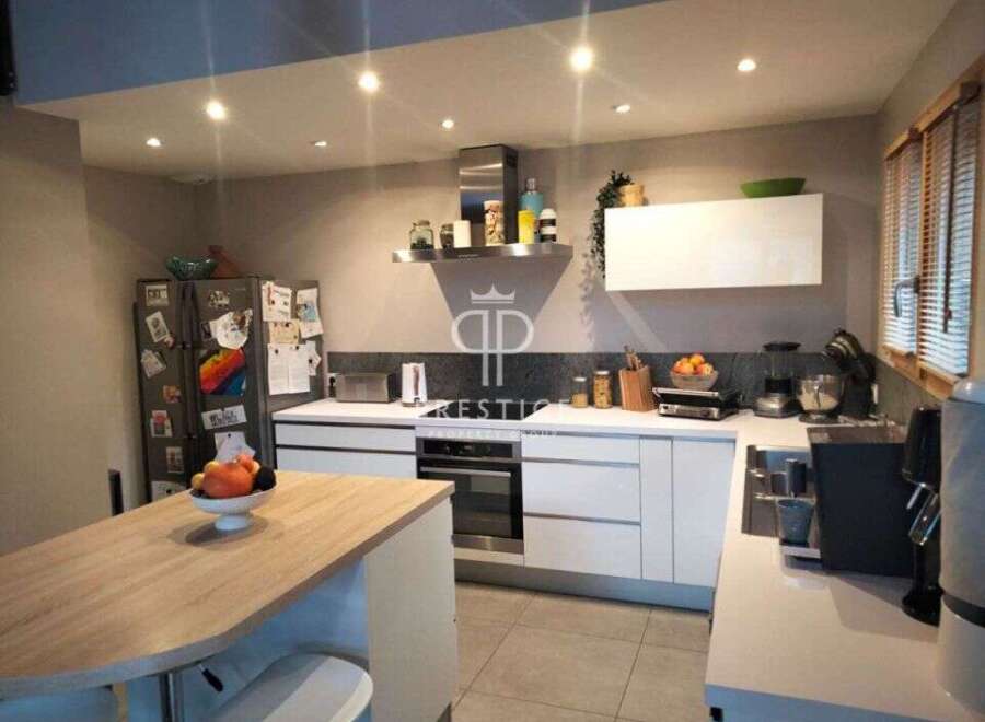 Modern kitchen with sleek white cabinetry and stainless steel appliances.