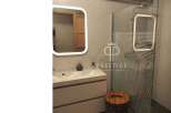 Modern bathroom design featuring a sleek vanity with a built-in sink and a stylish illuminated mirror.