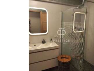 Modern bathroom design featuring a sleek vanity with a built-in sink and a stylish illuminated mirror.