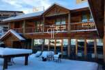 Discover a stunning wooden chalet nestled in a snowy landscape, perfect for a winter getaway.