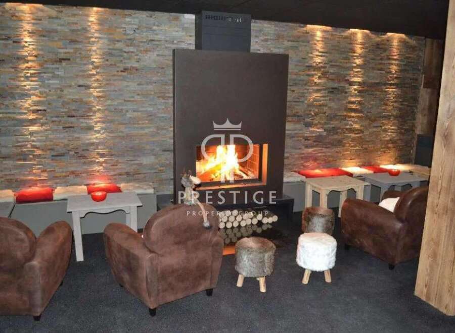 Cozy up in this luxurious lounge featuring a stunning fireplace and inviting seating.