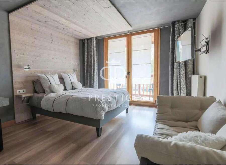 Discover a cozy bedroom retreat with a rustic wooden accent wall and a comfortable bed.