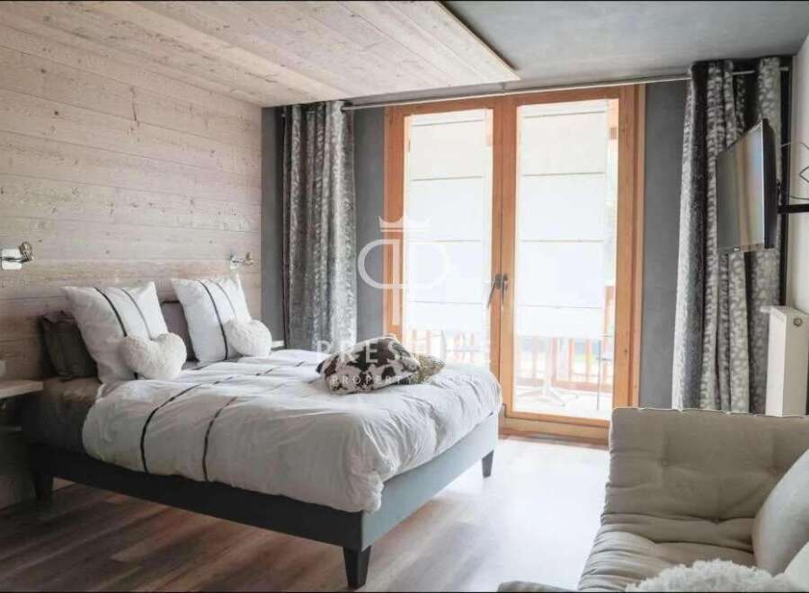 Discover a cozy bedroom retreat with a rustic wooden accent wall and a comfortable bed.