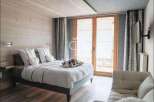 Discover a cozy bedroom retreat with a rustic wooden accent wall and a comfortable bed.