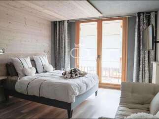 Discover a cozy bedroom retreat with a rustic wooden accent wall and a comfortable bed.