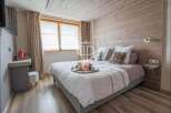 Cozy bedroom with a rustic wooden headboard and ceiling, creating a warm and inviting atmosphere.