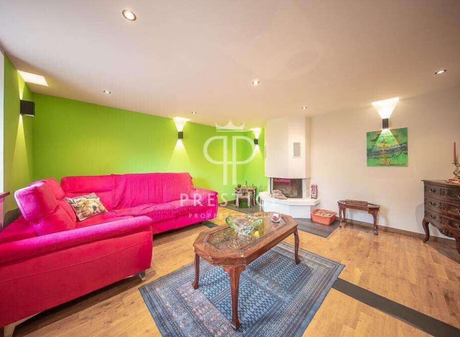 Discover this stunning property featuring a vibrant living room with a bold pink sofa and a striking green accent wall.