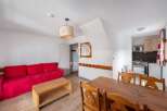 Discover this charming property featuring a cozy red sofa and a stylish wooden coffee table, perfect for relaxation.