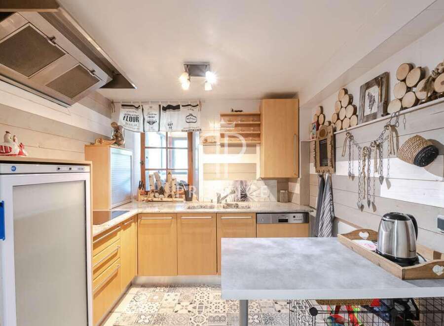 Charming kitchen with a rustic design, featuring wooden cabinets and a stylish countertop.
