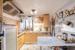 Charming kitchen with a rustic design, featuring wooden cabinets and a stylish countertop.