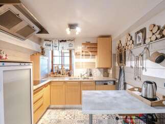Charming kitchen with a rustic design, featuring wooden cabinets and a stylish countertop.