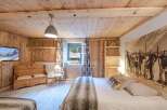 Experience rustic charm in this cozy bedroom, featuring warm wooden walls and ceilings.