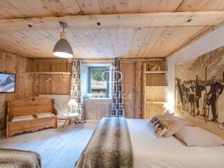 Experience rustic charm in this cozy bedroom, featuring warm wooden walls and ceilings.
