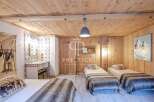 Experience rustic charm in this cozy bedroom, featuring warm wooden walls and ceilings.