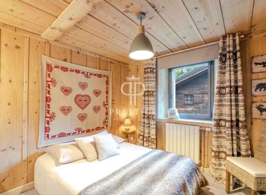 Cozy cabin bedroom with rustic wooden walls and ceiling.