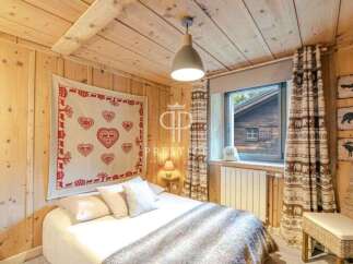 Cozy cabin bedroom with rustic wooden walls and ceiling.