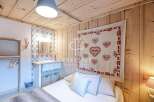 Cozy bedroom with rustic wooden walls and ceiling.