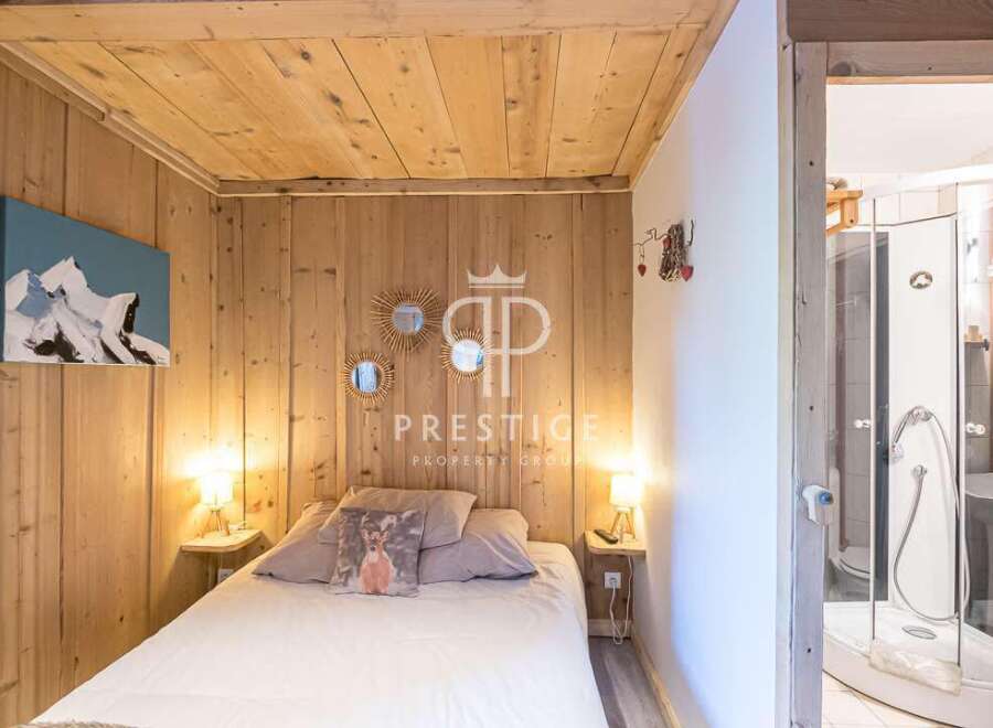 Discover the charm of this cozy bedroom, featuring rustic wooden walls and a warm, inviting ambiance.
