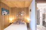 Discover the charm of this cozy bedroom, featuring rustic wooden walls and a warm, inviting ambiance.