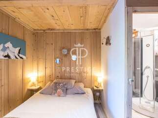 Discover the charm of this cozy bedroom, featuring rustic wooden walls and a warm, inviting ambiance.