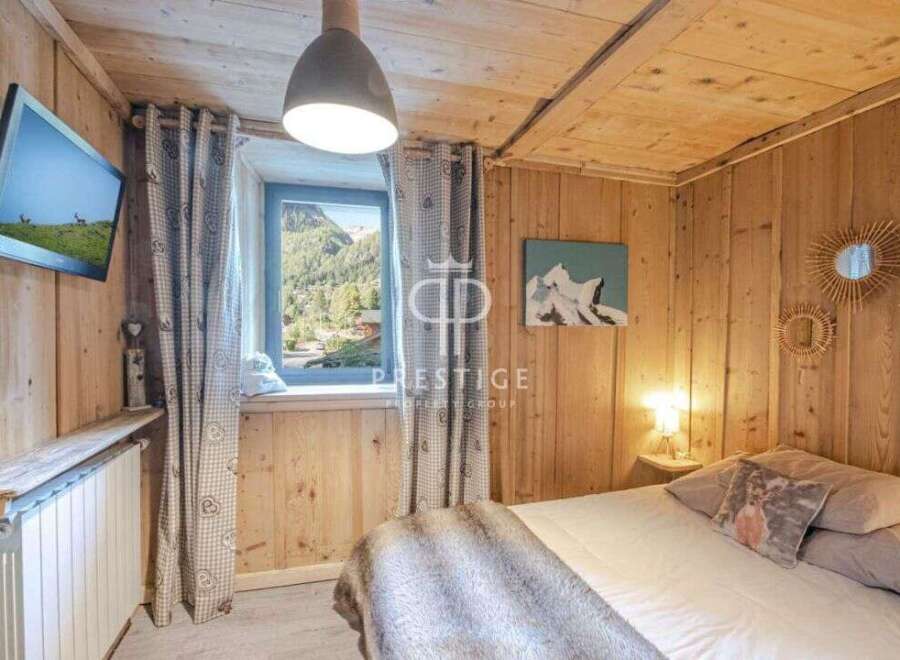Experience the charm of this cozy bedroom with its rustic wooden walls and ceiling.