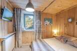 Experience the charm of this cozy bedroom with its rustic wooden walls and ceiling.