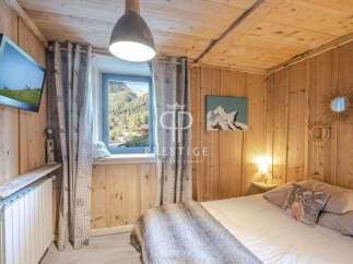 Experience the charm of this cozy bedroom with its rustic wooden walls and ceiling.