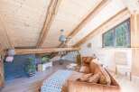 Discover the charm of this stunning property, featuring a cozy living space with exposed wooden beams and a unique sloped ceiling.