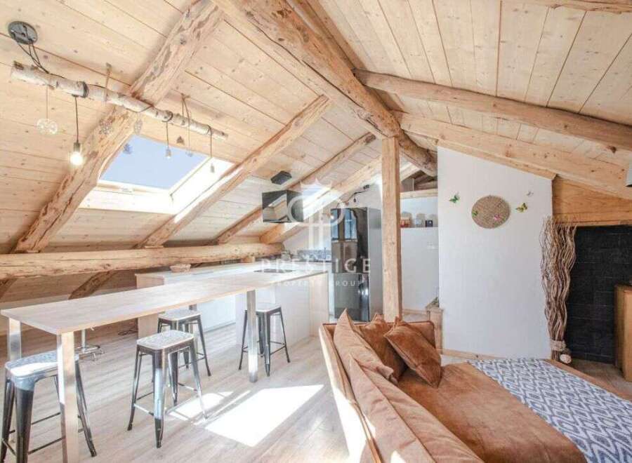 Discover the charm of this stunning attic space, featuring exposed wooden beams and a unique skylight.