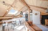 Discover the charm of this stunning attic space, featuring exposed wooden beams and a unique skylight.