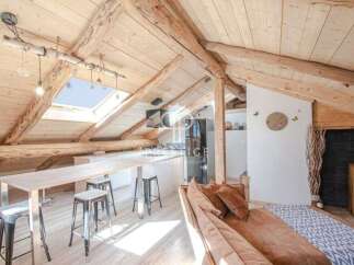 Discover the charm of this stunning attic space, featuring exposed wooden beams and a unique skylight.